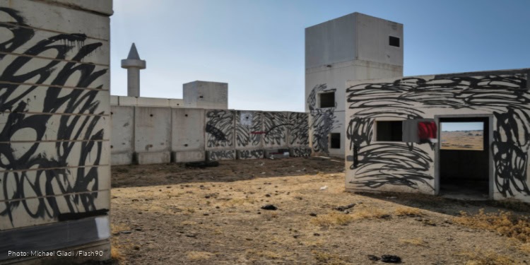 Street Art and Graffiti Artist Vered Dror sprays a Graffiti quote of slain Egyptian former president Anwar Sadat onto the walls of an IDF military urban warfare training facility, El Poran, Golan Heights, June 28, 2025.