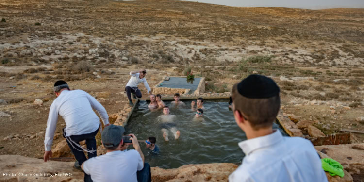 Ultra-Orthodox Jews enjoy the water during a heat wave in Pnei Kedem, West Bank, August 13, 2025.