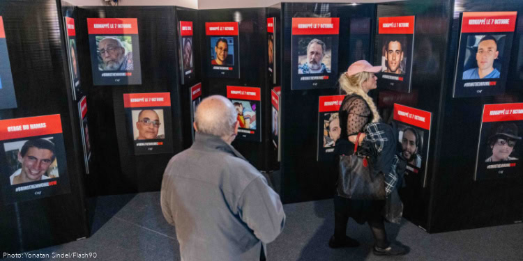 People look at photographs of hostages kidnapped by Hamas terrorists and taken to Gaza on October 7, 2023, at a Sukkah in Paris, France, on October 7, 2025.