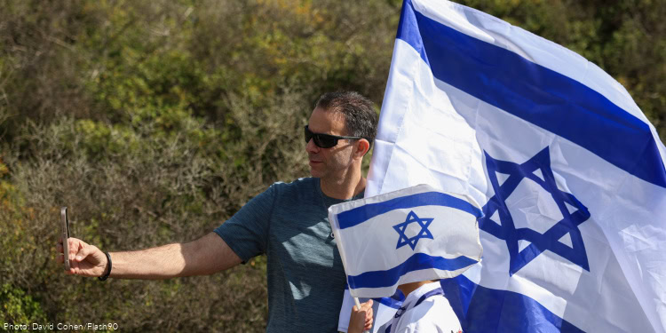 People wait for the arrival of freed hostage Alon Ohel outside his home in Moshav Lavon, northern Israel, October 24, 2025.