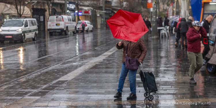 People walk in the rain outside the Mahane Yehuda Market in Jerusalem, January 9, 2026.