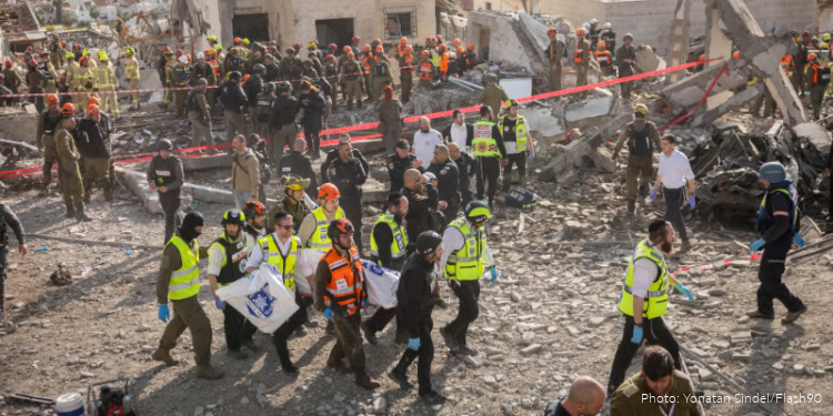 Emergency responders and volunteers work together to rescue victims from the rubble of a collapsed building in a disaster zone.