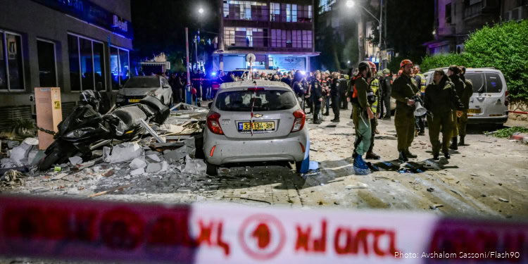 Israeli security and rescue forces inspect the damage at the scene where a missile fired from Iran toward Israel caused damage and killed two people in Ramat Gan, central Israel, March 18, 2026