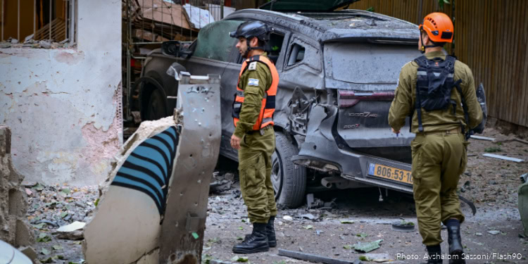 U.S. officials monitor a damaged vehicle in a conflict zone, highlighting ongoing efforts to influence Iran's regional activities. The image underscores diplomatic and strategic initiatives related to.
