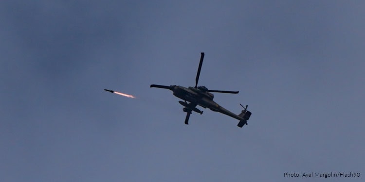 Military helicopter firing missile during a conflict, symbolizing ongoing tensions in the Middle East related to Hezbollah and Iran.