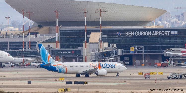 View of a Dubai Airlines airplane on the tarmac at Ben Gurion Airport in Tel Aviv, with terminal building in the background.