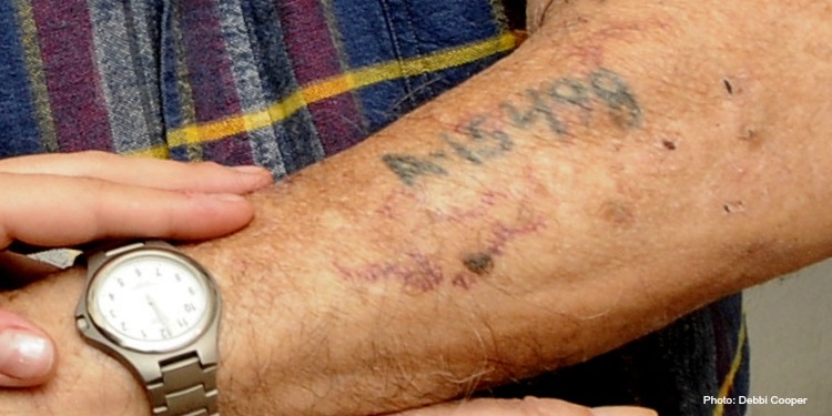 Close up image of a person showing their Holocaust tattoo.