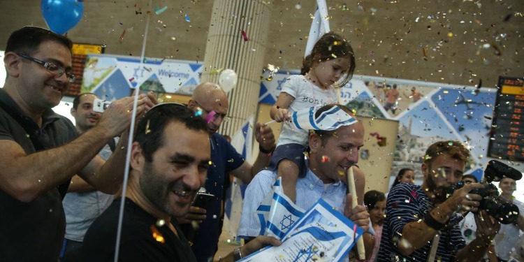 Family celebrating in the airport with confetti after making Aliyah.