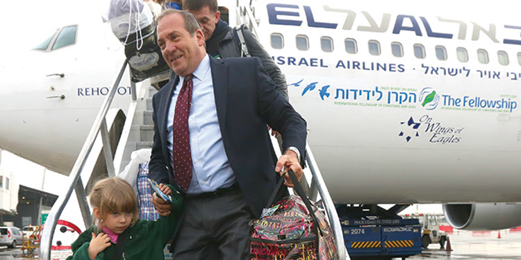 Rabbi Eckstein helping a young girl with her bags off an Aliyah flight.