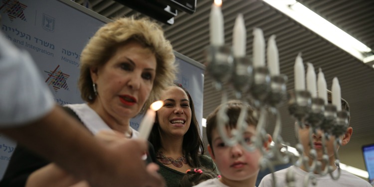 Yael Eckstein and four others lighting a menorah.