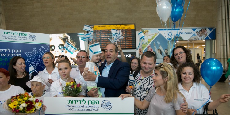 Rabbi Yechiel Eckstein with people who came on a Freedom Flight holding Israeli flags.