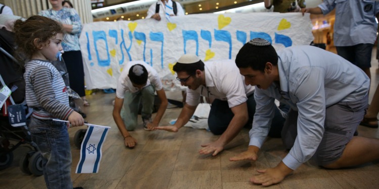 Group of Jewish man arriving in Israel after a freedom flight and blessing the ground