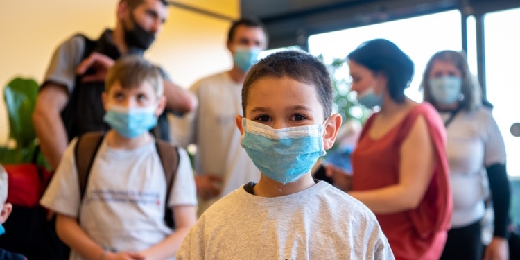 Young boy with a mask on his face who just came off an Aliyah flight.