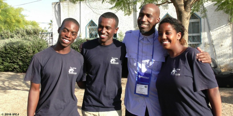 Group of four smiling into the distance or at the camera.