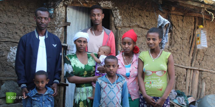 Ethiopian family standing in front of house