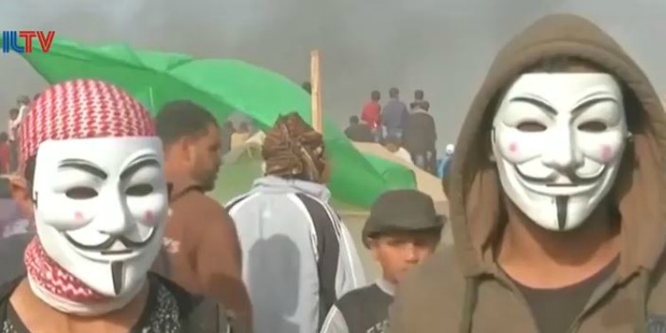 Two men with masks on in the middle of a crowd.