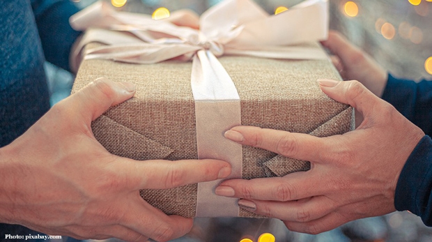 Two people holding on to each side of a present.