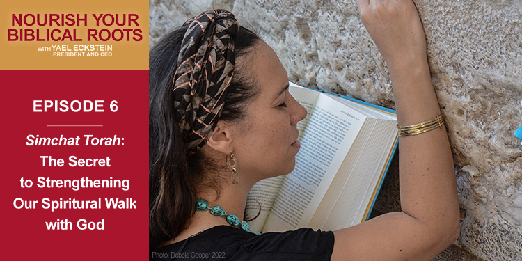 Yael Eckstein with a Bible in her hand praying against the Western Wall with a Nourish Your Biblical Roots background.