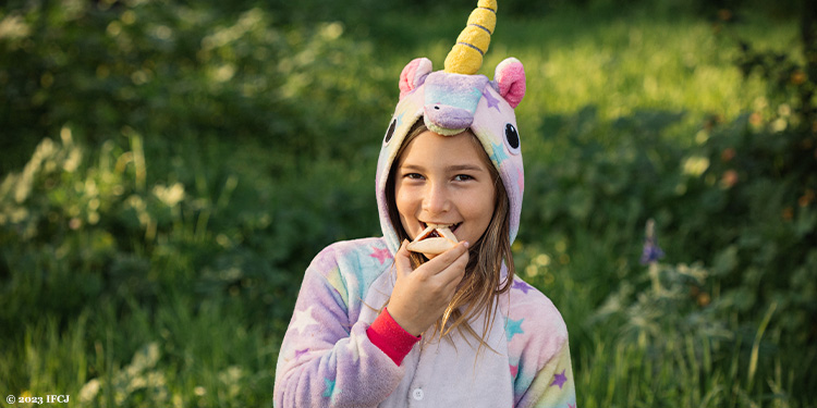 One of Yael Eckstein's daughters dressed up for Purim while eating a cookie.