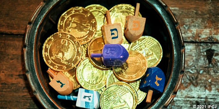 A bowl of dreidels and gold coins for Hanukkah. 