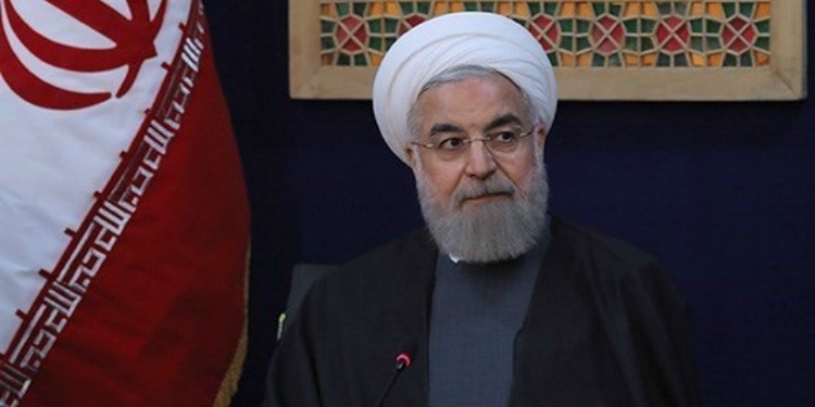 Iranian President Hassan Rouhani in front of the flag of Iran