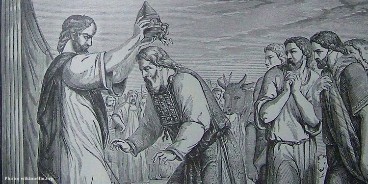A man giving Aaron a crown, anointing him as High Priest as many people watch behind them.