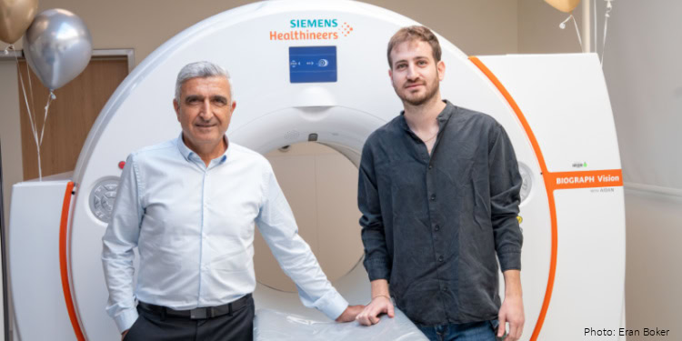 Two men standing beside a Siemens Healthineers PET-CT scanner at Hillel Yaffe Medical Center, showcasing modern medical imaging technology for cancer diagnosis.