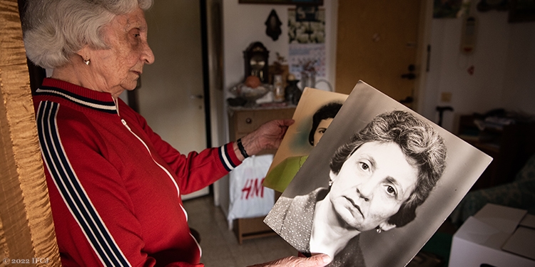 An elderly Jewish woman looking back at old photos of herself