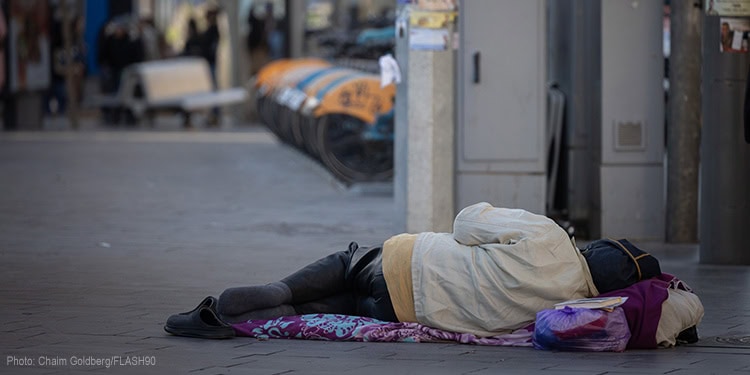 Homeless person laying on the sidewalk