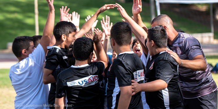 A team of soccer players huddling during a game
