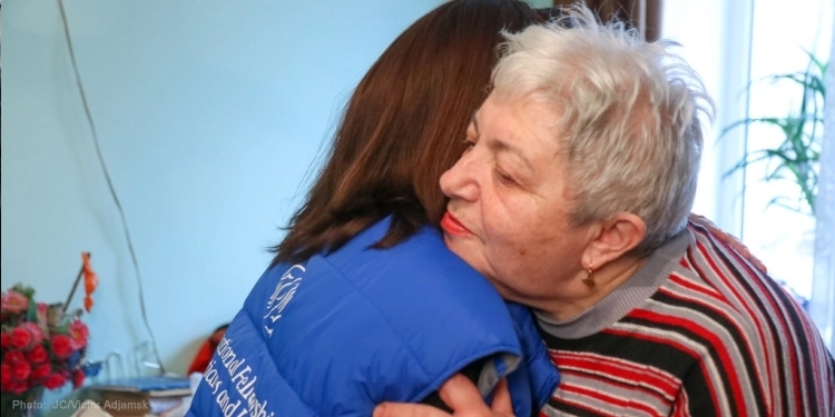 Elderly Jewish woman hugging an IFCJ worker.