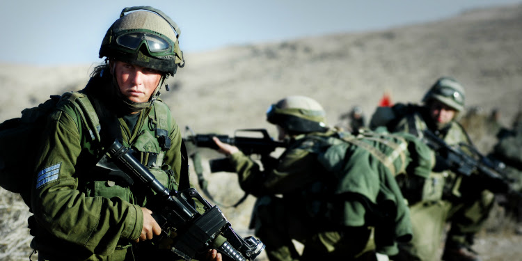 Three IDF soldiers scoping out the premise on the field.