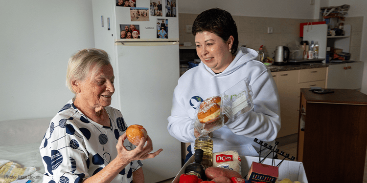 IFCJ Staff giving food box to elderly woman