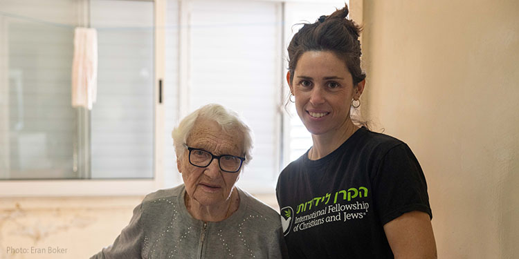 IFCJ Staff standing with elderly woman