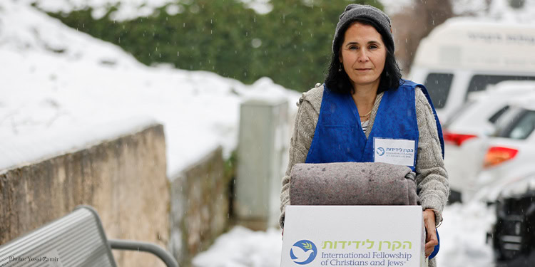 IFCJ Staff walking through snow to deliver a food box and blanket