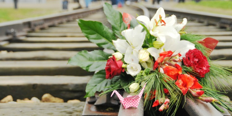 A bouquet of flowers lying on top of railroad tracks for Holocaust Remembrance