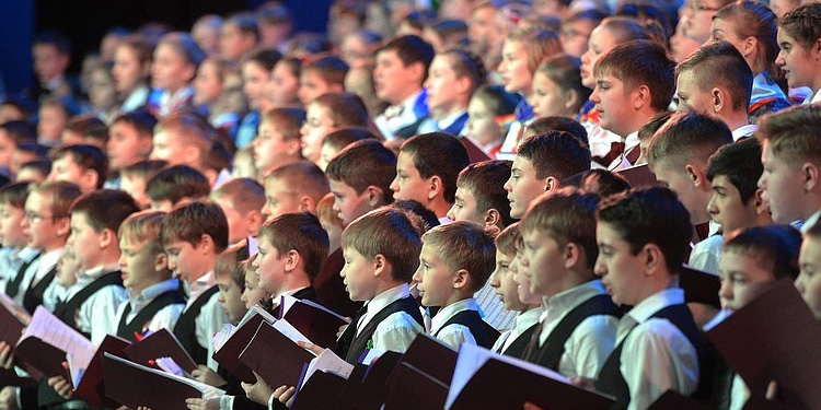 Several children in uniform singing for their choir.