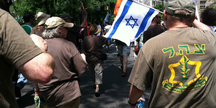 Several people wearing brown shirts while walking in a parade in New York celebrating Israel Day.