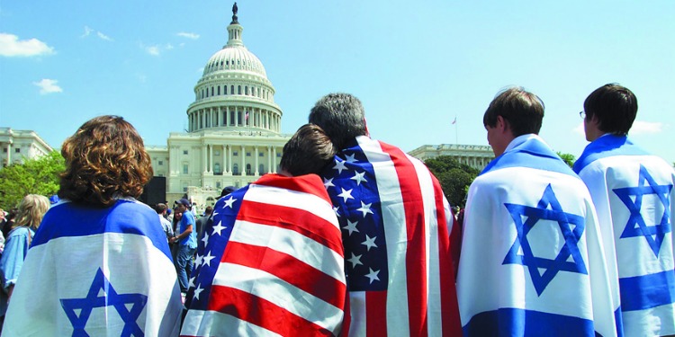 Two people draped in American flags and three people draped in Israeli flags looking at the Capitol of the United States of America.