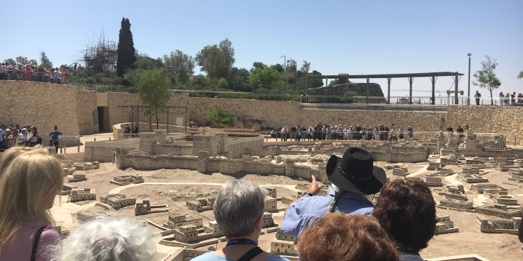 Visitors overlooking a model of Israel at a museum.