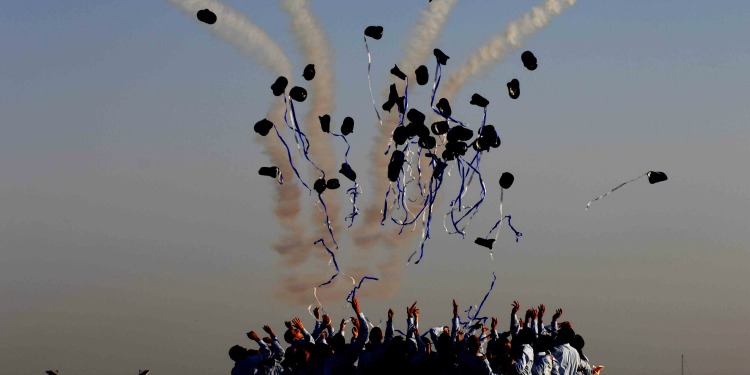 Group of graduates tossing their caps into the air.
