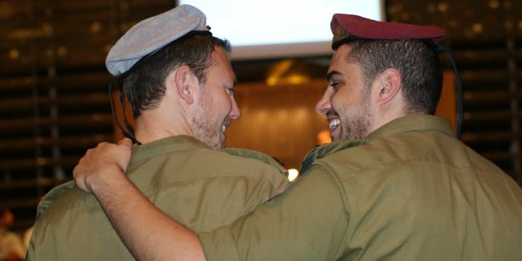 Two soldiers embracing each other and smiling.