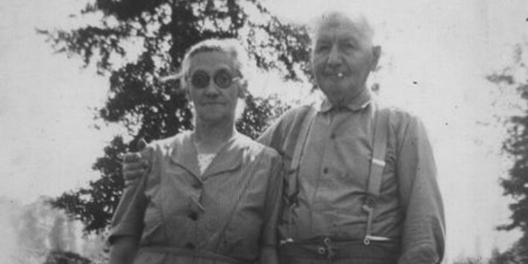 Black and white image of a couple looking directly into the camera.