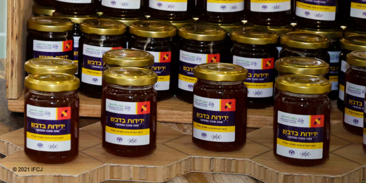 Several jars of honey with gold tops