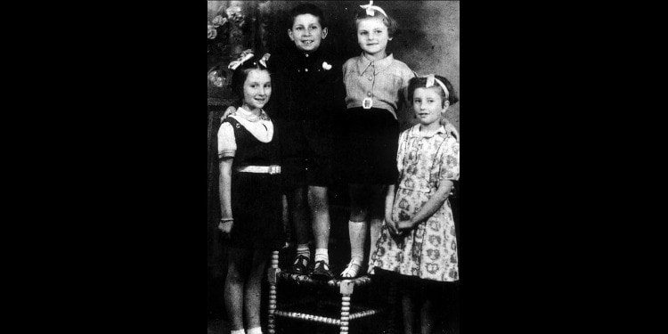 Dated black and white image of four children smiling.
