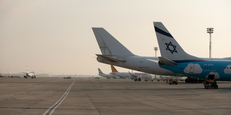 A freedom flight plane on the tarmac parked next to other planes.