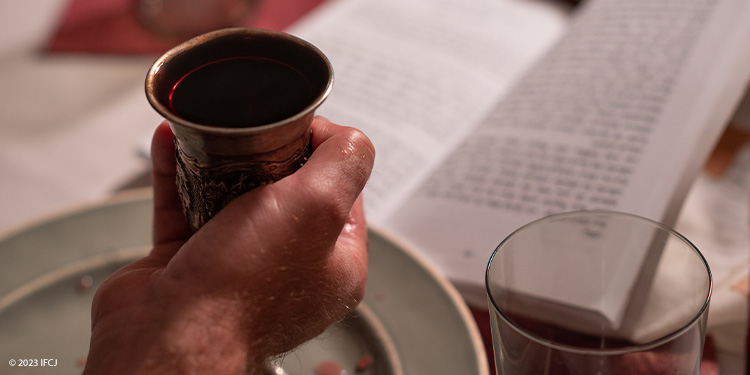 Kiddush cup held as blessings are read for the beginning of Shabbat.