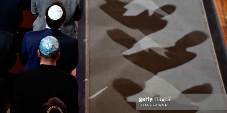 Men standing in a line wearing kippahs.