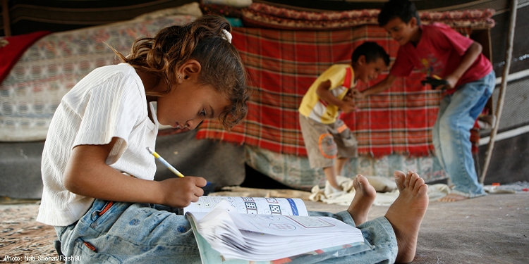 Little girl sitting on the floor doing her homework