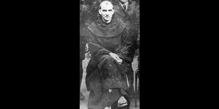 Old photo of Holocaust victim Father Jacques de Jesus, sitting and smiling in tattered priest robes